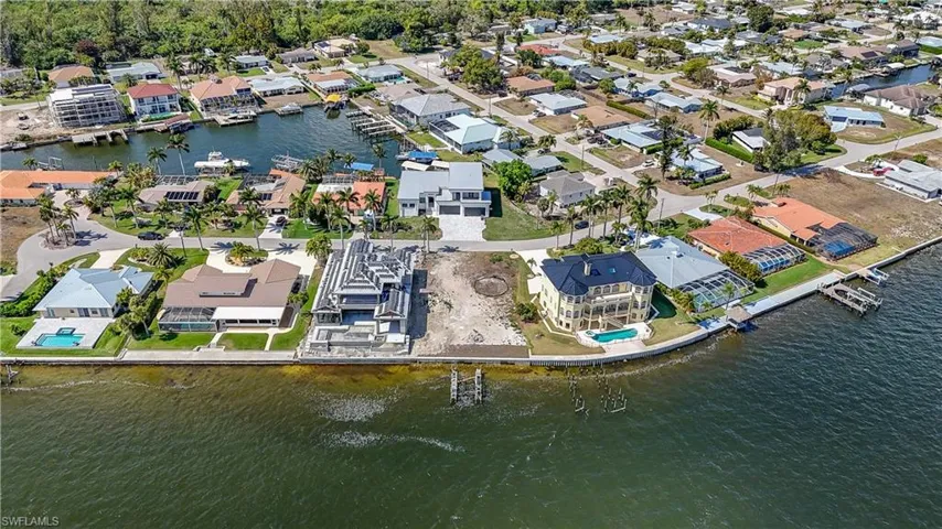 Aerial view of property and surrounding area with a large body of water and nearby suburban area