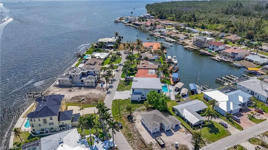 Aerial view of property and surrounding area featuring nearby suburban area and a nearby body of water