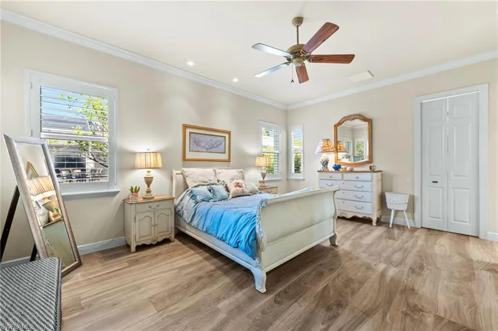 Bedroom featuring light wood-type flooring, ornamental molding, a ceiling fan, and recessed lighting