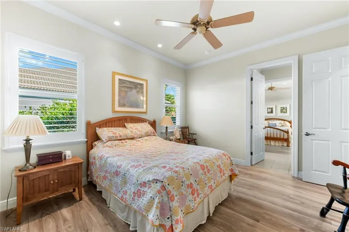 Bedroom with light wood-style flooring, crown molding, ceiling fan, and recessed lighting