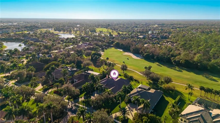 Aerial overview of property's location featuring nearby suburban area, a golf course, and a nearby body of water