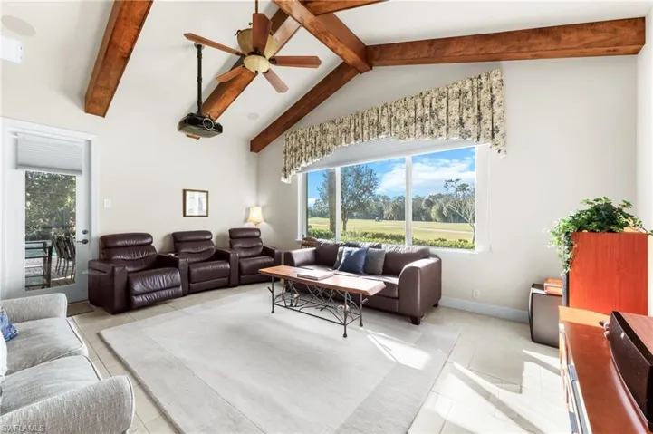 Living area featuring a ceiling fan, view of golf course, plenty of natural light, and light tile patterned floors