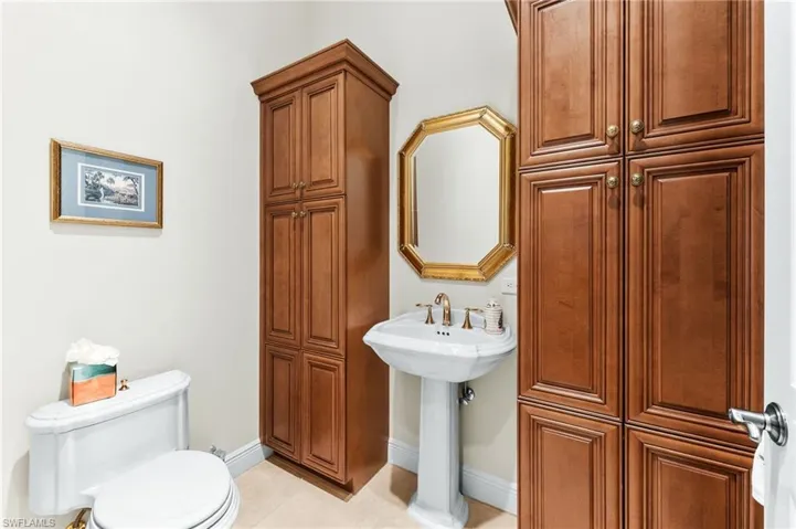 Half bathroom featuring toilet and light tile patterned floors