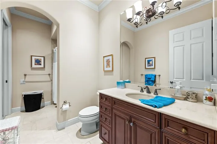 Bathroom featuring curtained shower, vanity, and ornamental molding
