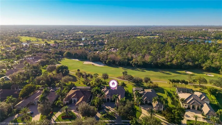 Aerial view of property's location featuring a golf club and nearby suburban area