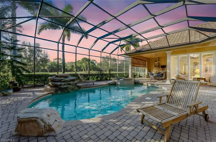 Integrated pool / spa with a sunroom, glass enclosure, and a patio area