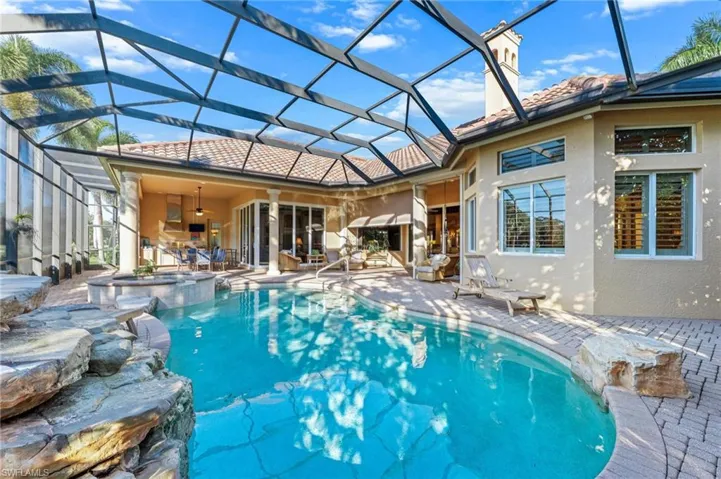 Integrated pool / spa featuring a sunroom, a patio area, and glass enclosure