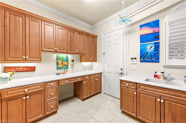 Kitchen with wood finish cabinets, crown molding, and light countertops