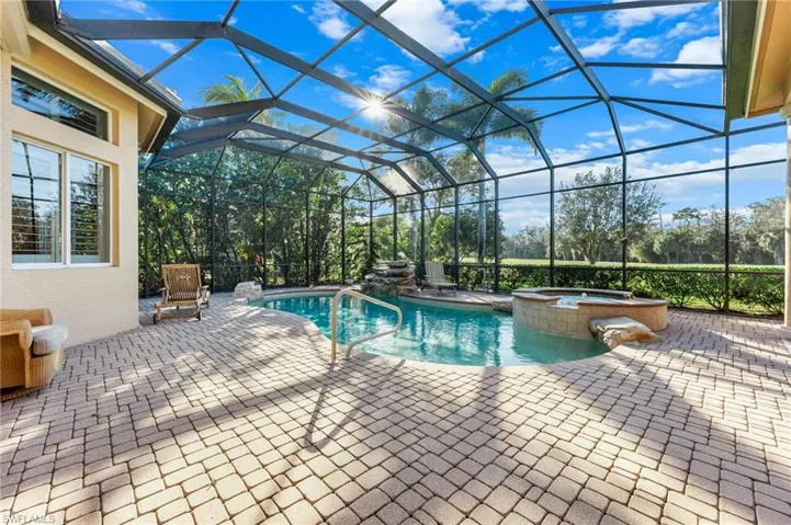 Relaxing pool / spa featuring a patio area, a sunroom, and a lanai