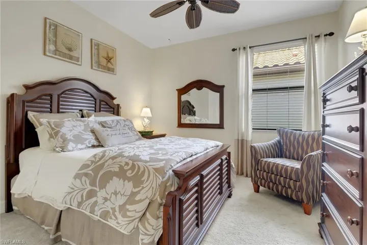 Bedroom with light colored carpet and a ceiling fan