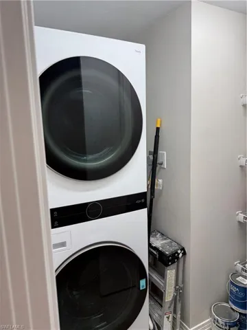 Laundry area featuring baseboards and stacked washer and dryer