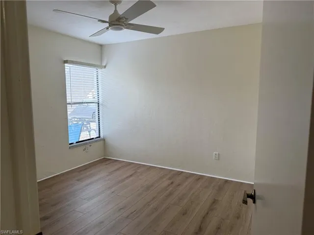 Spare room with wood finished floors and a ceiling fan