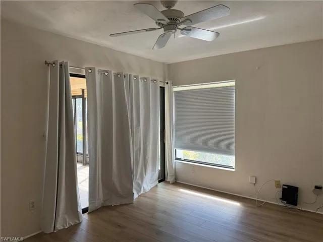 Spare room with wood finished floors and a ceiling fan