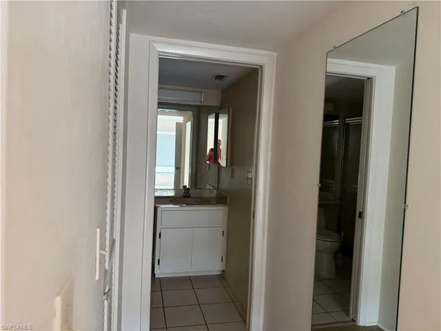 Hall with light tile patterned floors and a sink