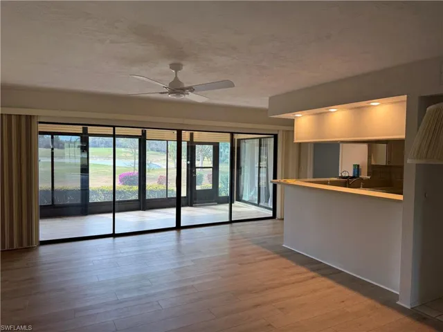Unfurnished living room with a ceiling fan and light wood-type flooring