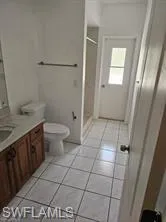 Bathroom with vanity, a shower stall, tile patterned floors, and toilet