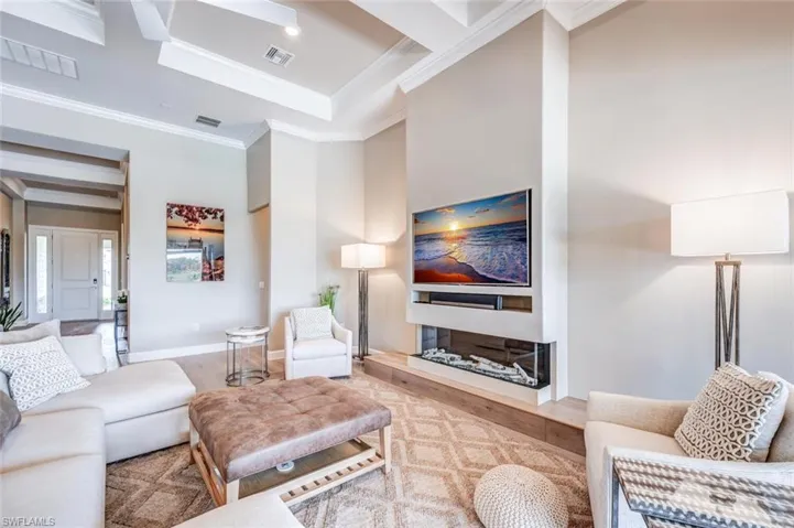 Living room with hardwood / wood-style floors, ornamental molding, beam ceiling, and coffered ceiling