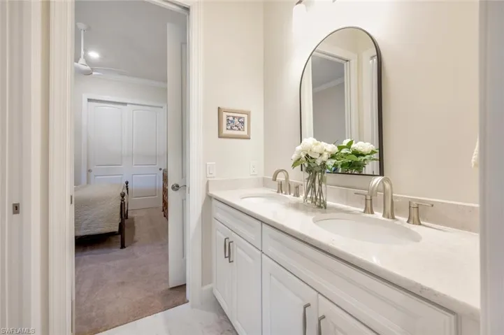 Bathroom featuring crown molding, double sink, and large vanity