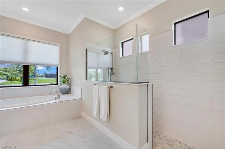 Bathroom with tile flooring, crown molding, and plus walk in shower