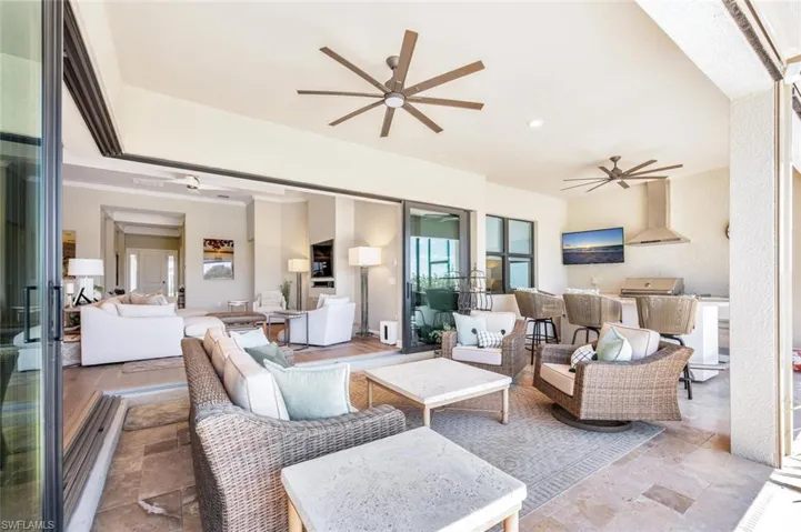 Living room with ceiling fan and light tile floors