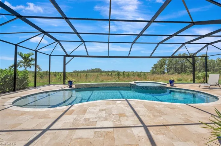 View of pool with a patio area, a lanai, and an in ground hot tub