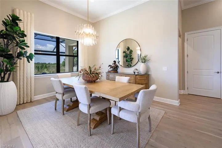 Dining area featuring ornamental molding, an inviting chandelier, and hardwood / wood-style floors
