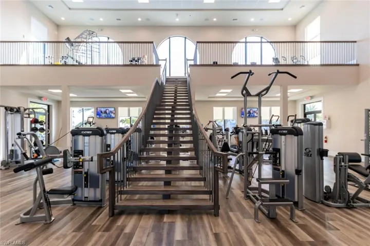 Exercise room with a high ceiling and hardwood / wood-style floors