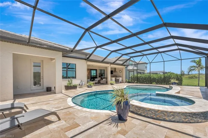 View of pool with a lanai, an in ground hot tub, and a patio