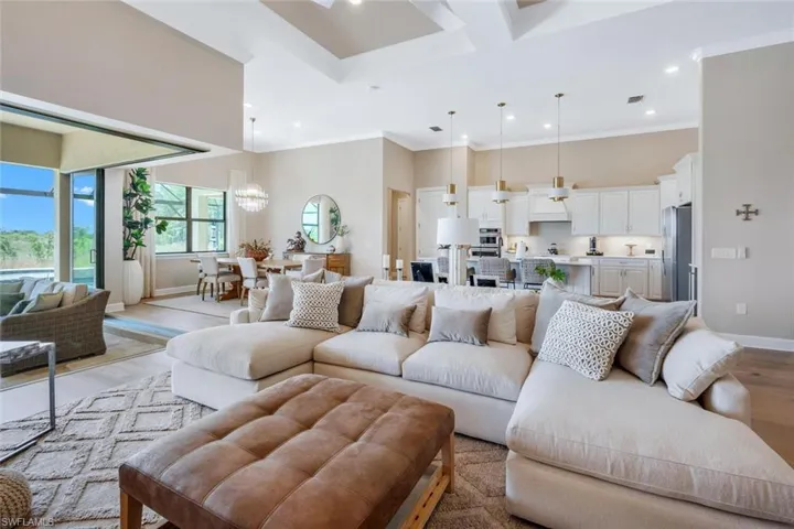 Living room featuring crown molding, coffered ceiling, and light hardwood / wood-style flooring