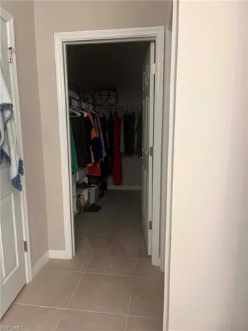 Walk-in closet with carpet flooring, a white trim doorway, and neutral-toned wall paint