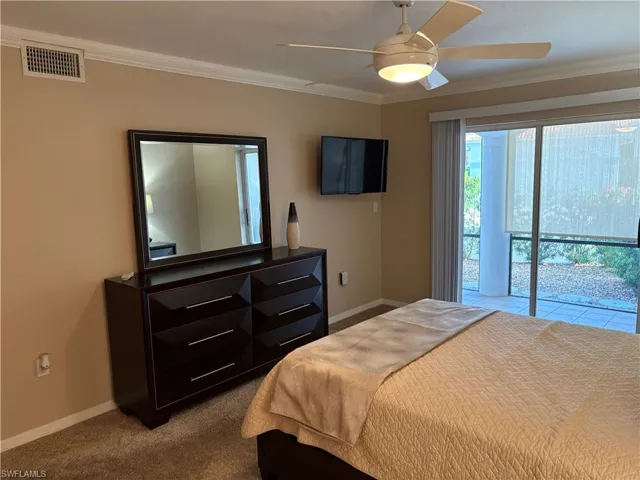 Bedroom with baseboards, visible vents, and ornamental molding