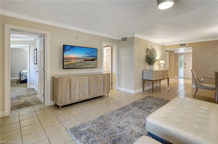 Tiled living room featuring crown molding