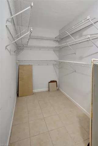 Walk in closet with tile patterned floors and water heater