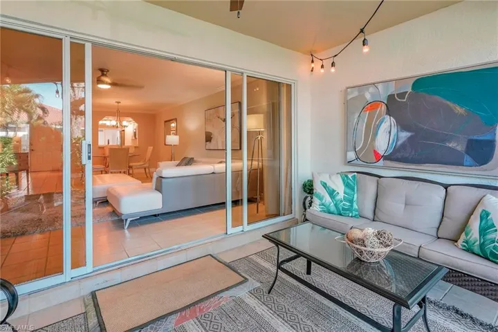 Sunroom / solarium featuring ceiling fan with notable chandelier