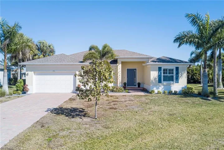 Ranch-style house featuring stucco siding, driveway, a garage, and a front yard