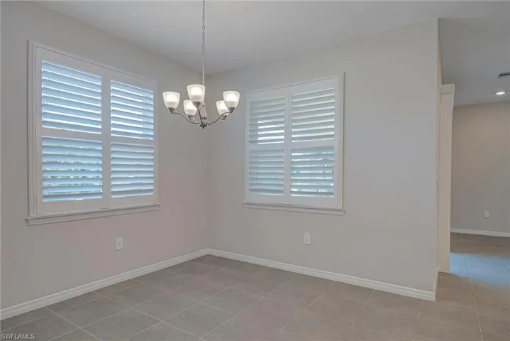 Breakfast area featuring hanging lights, plenty of natural light, and light tile patterned floors