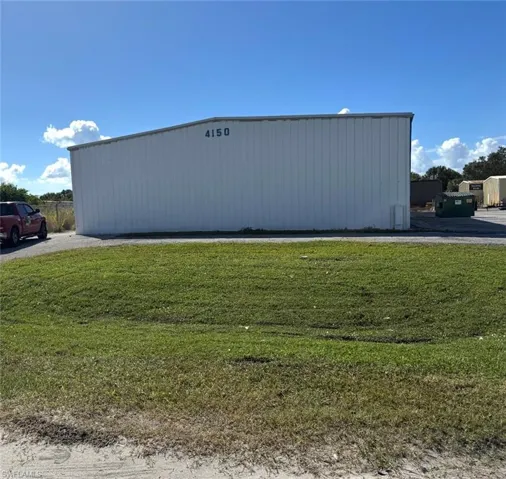 View of pole building with a yard