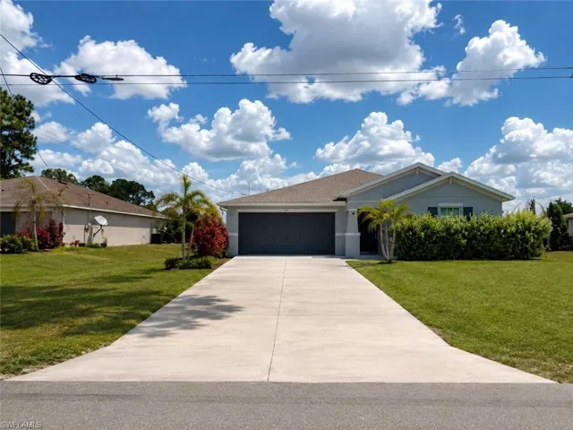 Contemporary single-story residence featuring a gray exterior and a concrete driveway