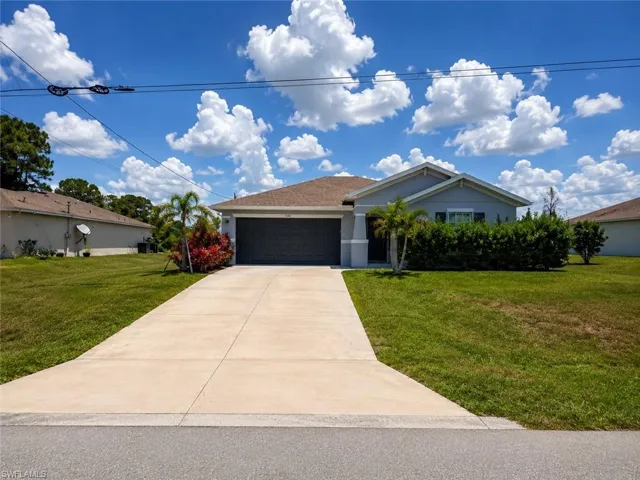 Single-story exterior with a garage, concrete driveway, and front lawn