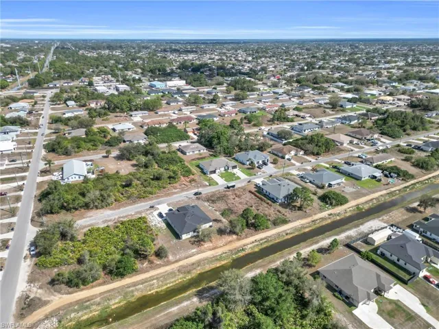 Aerial view of property and surrounding area featuring nearby suburban area