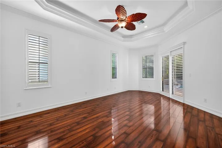 Spare room with crown molding, hardwood / wood-style flooring, a raised ceiling, ceiling fan, and recessed lighting
