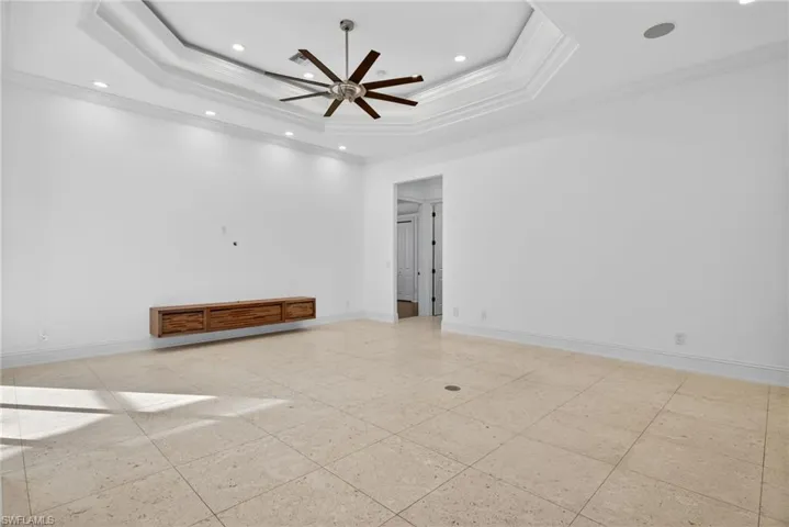 Spare room featuring a tray ceiling, ornamental molding, recessed lighting, and ceiling fan