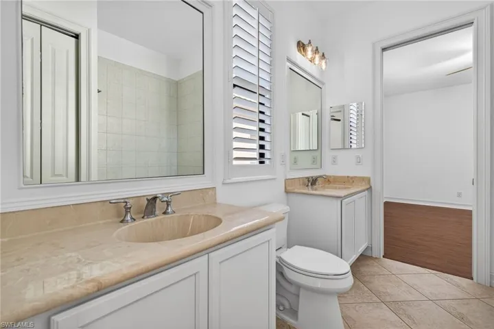Bathroom with two vanities and light tile patterned flooring