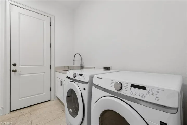 Laundry room with washing machine and clothes dryer and cabinet space