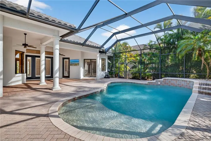 Outdoor pool with glass enclosure, a patio area, a sunroom, and french doors