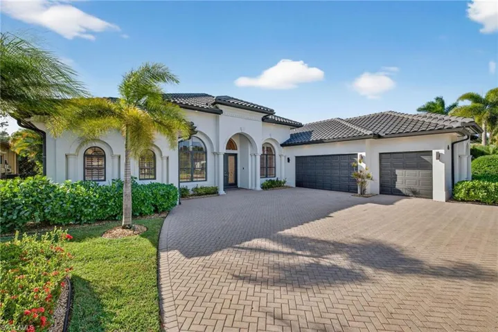 Mediterranean / spanish home featuring an attached garage, decorative driveway, and stucco siding