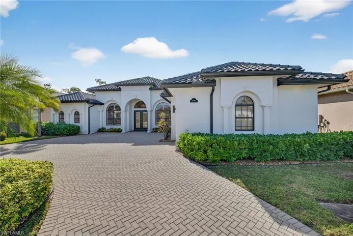 Mediterranean / spanish-style home with decorative driveway and stucco siding