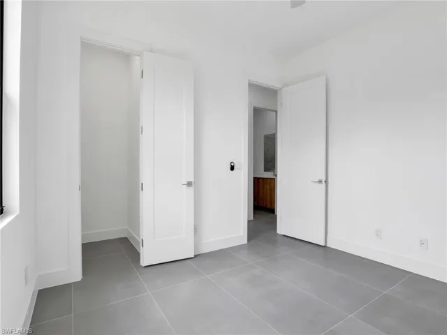 Unfurnished bedroom with baseboards and light tile patterned floors