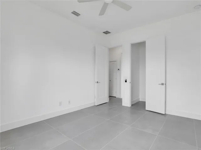 Unfurnished bedroom featuring a ceiling fan and light tile patterned floors