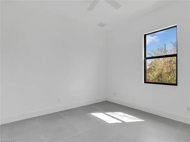 Spare room with light tile patterned flooring and ceiling fan
